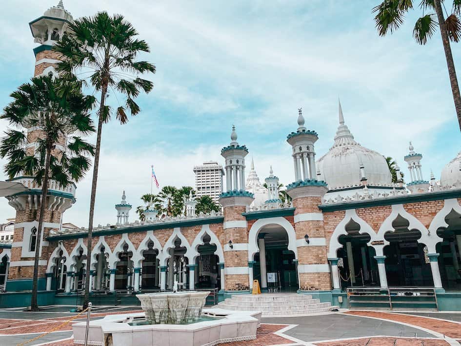 old mosque with palm trees next to it