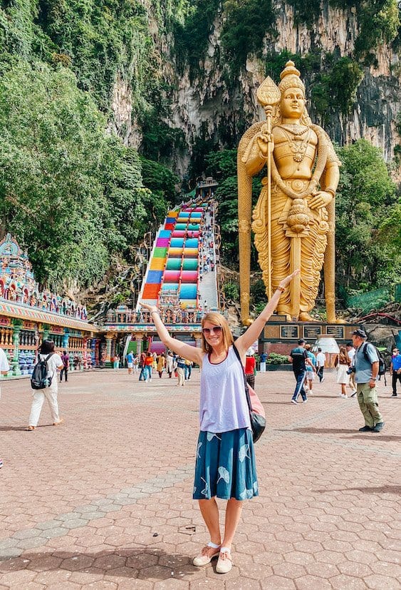Woman in front of golden statue and colourful steps at Batu Caves