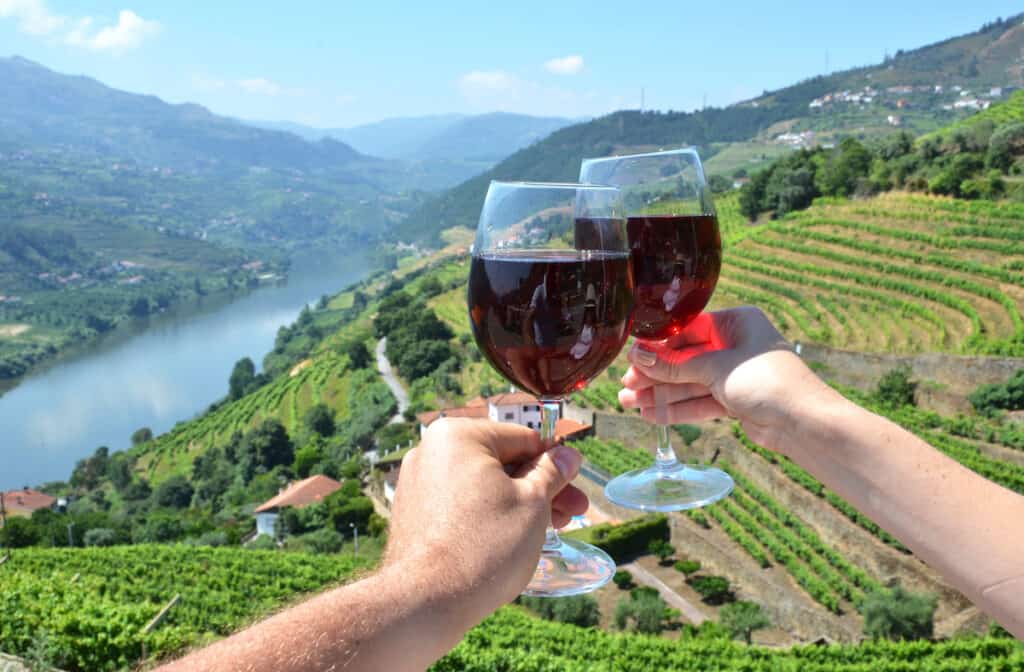 Wine glasses against vineyards in Douro Valley, Portugal