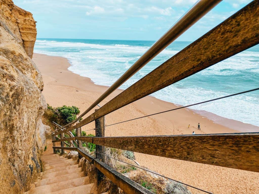Wooden steps on the side of a cliff leading down to the beach