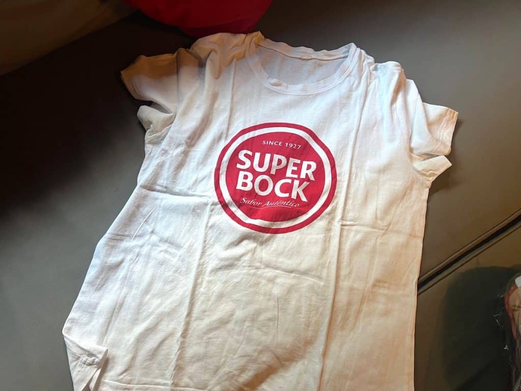 T-shirt on the floor with Super Bock logo on it, a Portuguese beer brand