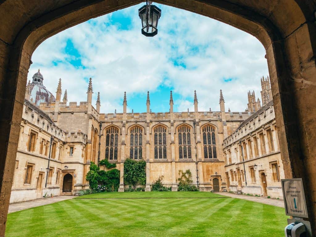 View through an archway to a courtyard surrounded by a historic building in Oxford