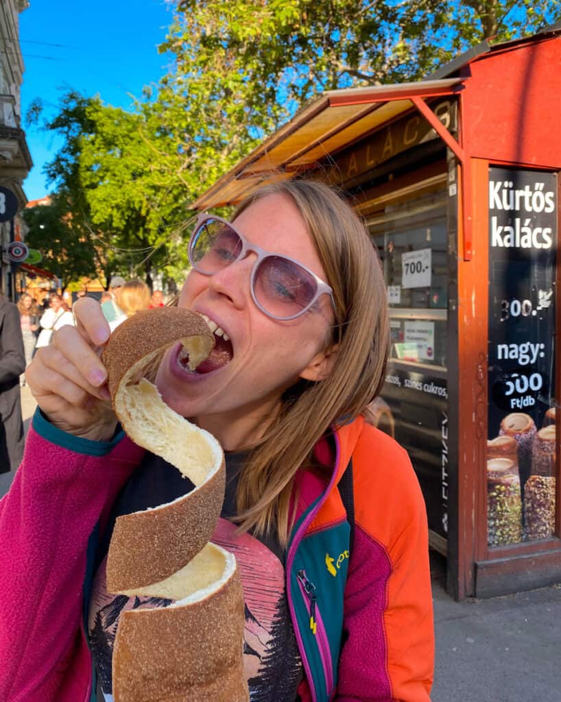 Tina eating chimney cake in Budapest, not that handy to pack but so delicious it's one of the best souvenirs from Budapest