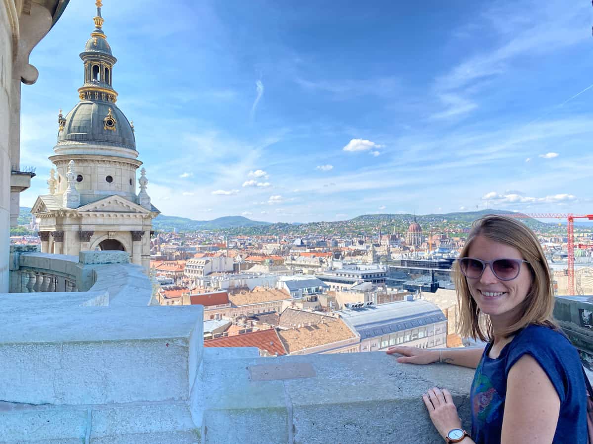 Tina at a viewing platform on a building, you can see the city skyline of Budapest. Is Budapest worth visiting? Yes it is for views like that