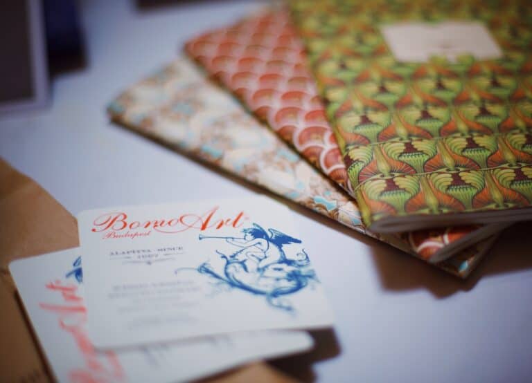 3 notepads on a table next to a business card