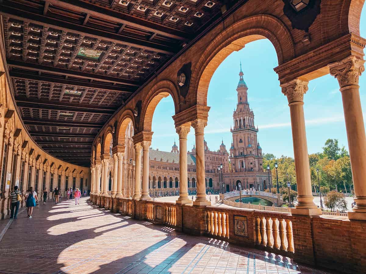 View through an archway to a beautiful tower at Plaza España; a must-see spot on any 3 days in Seville itinerary