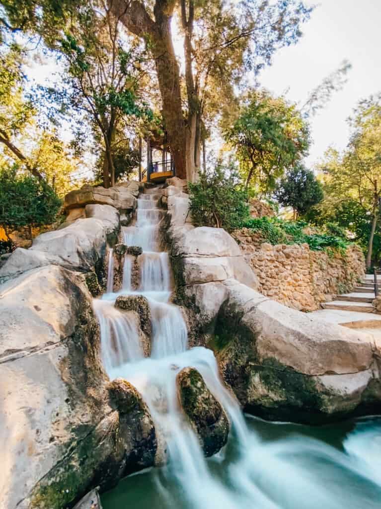 A small waterfall running down a rock slide inside the main park in Seville