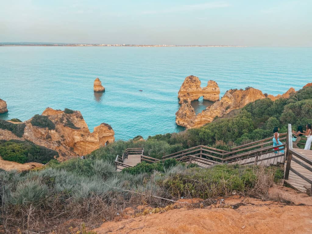 The coastline near Lagos with wooden steps leading down to the beach. This stunning coastline makes you answer the question: Is Lagos worth visiting? with yes
