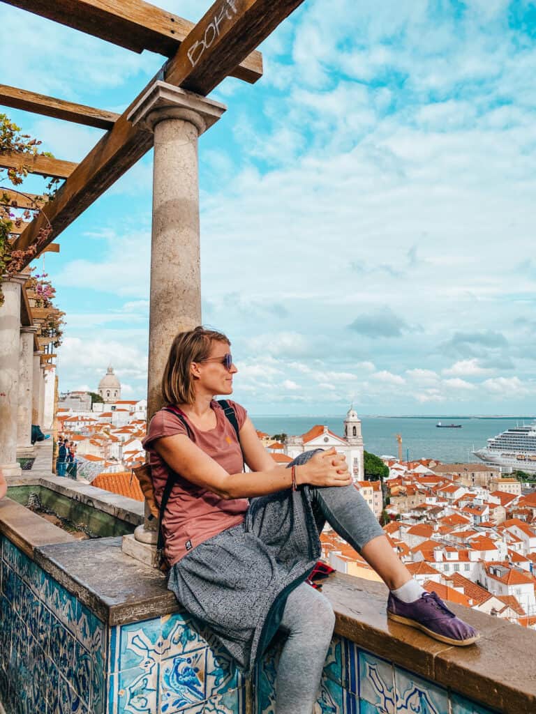Tina sitting on a wall looking over the Lisbon skyline