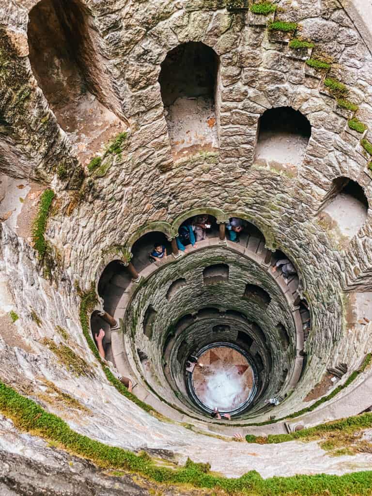 View down a well, there's a stairwell leading to the bottom; Is Sintra worth visiting? Yes, so you can see this amazing well