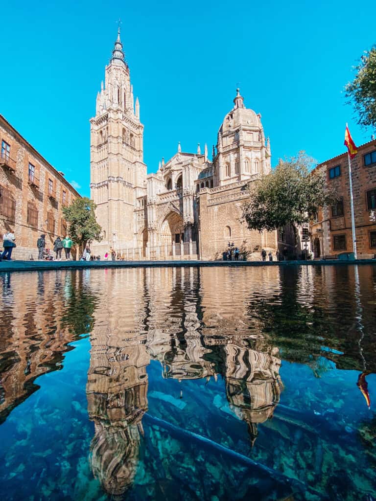 The cathedral of Toledo reflecting in a small pond; one of the great things to see on a Toledo day trip from Madrid