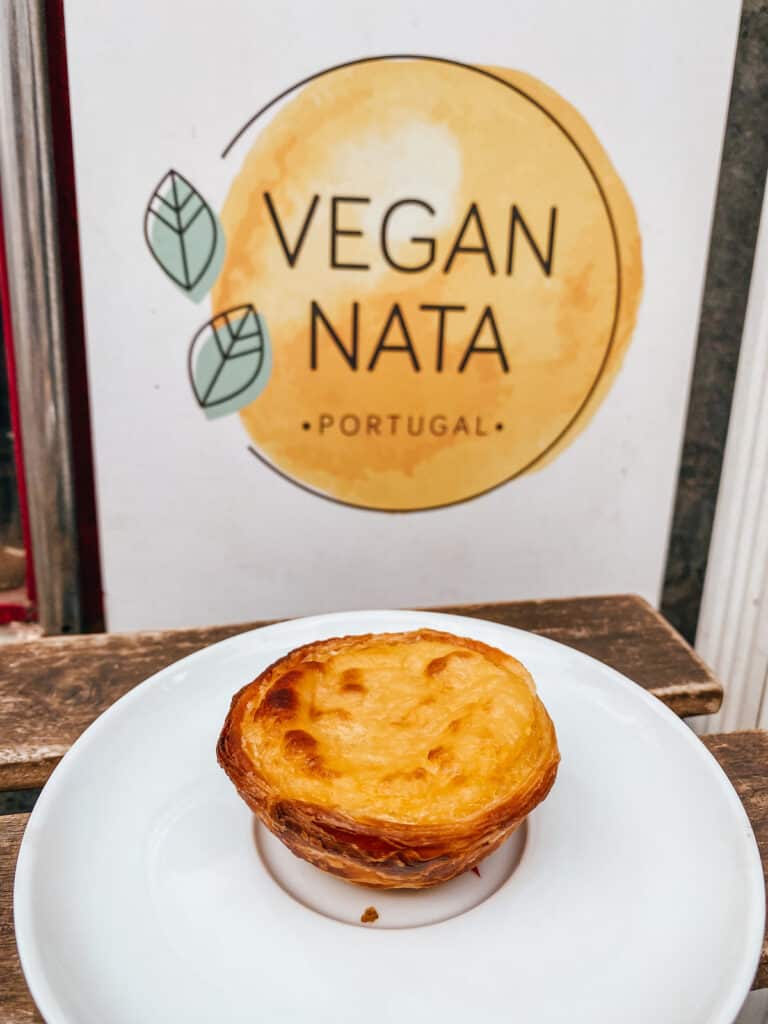 A vegan pastel de nata on a plate in front of a poster of one