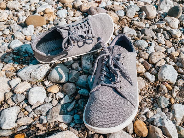A pair of Feelgrounds barefoot shoes on a stoney beach