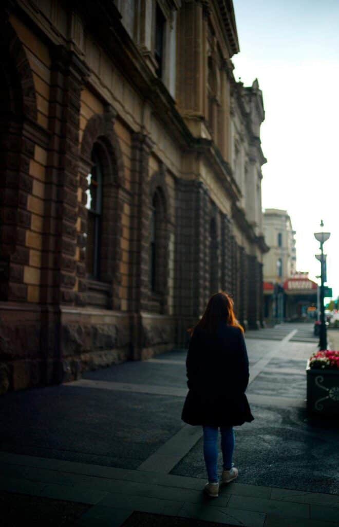 A woman walking on a pavement in autumn in Melbourne