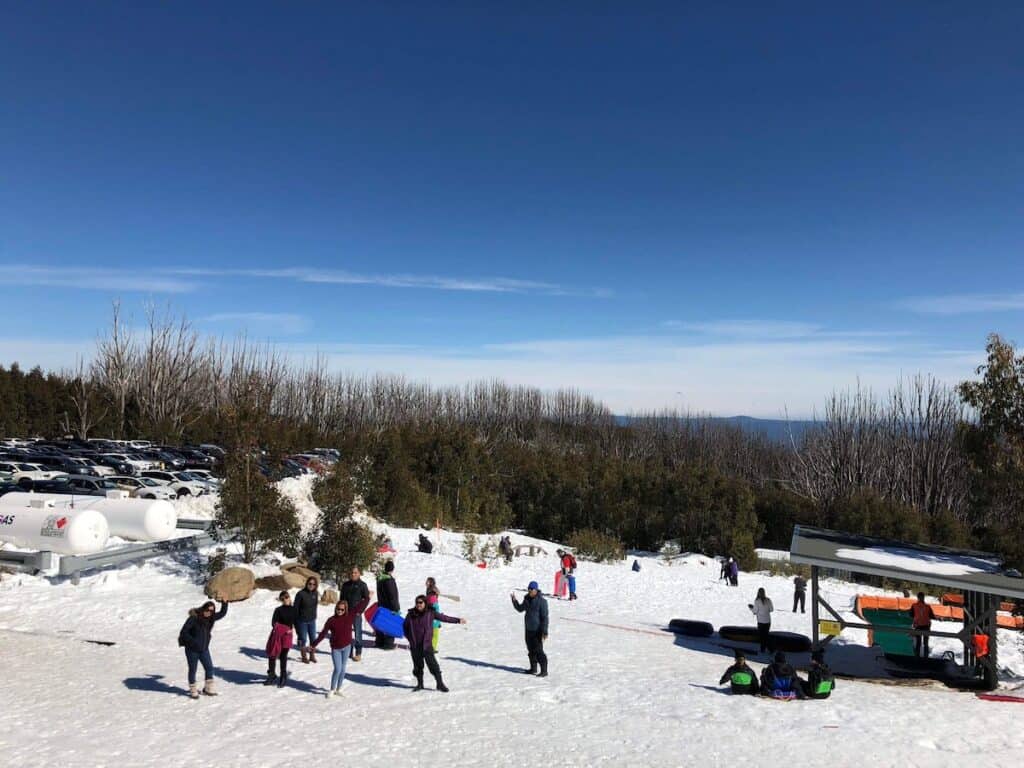 A snowy landscape with lots of people enjoying the snow. Does it snow in Australia Melbourne? Almost never in the city center but in the mountains in Victoria