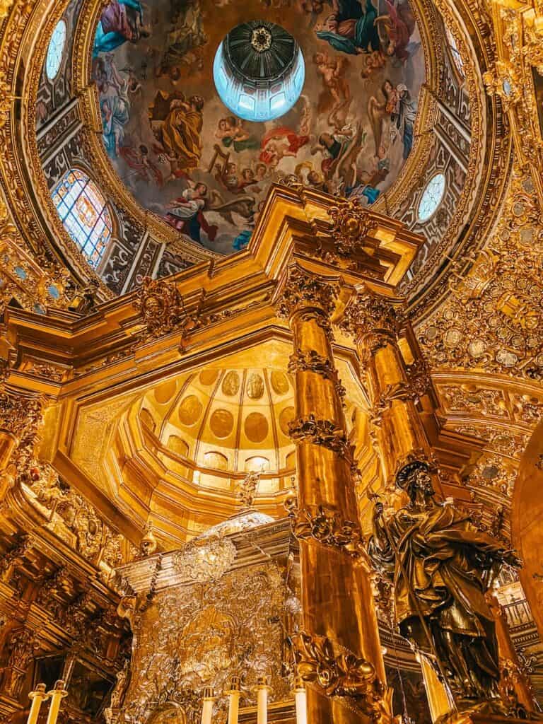 A opulent golden chest with the remains of a saint inside at Basílica de San Juan de Dios