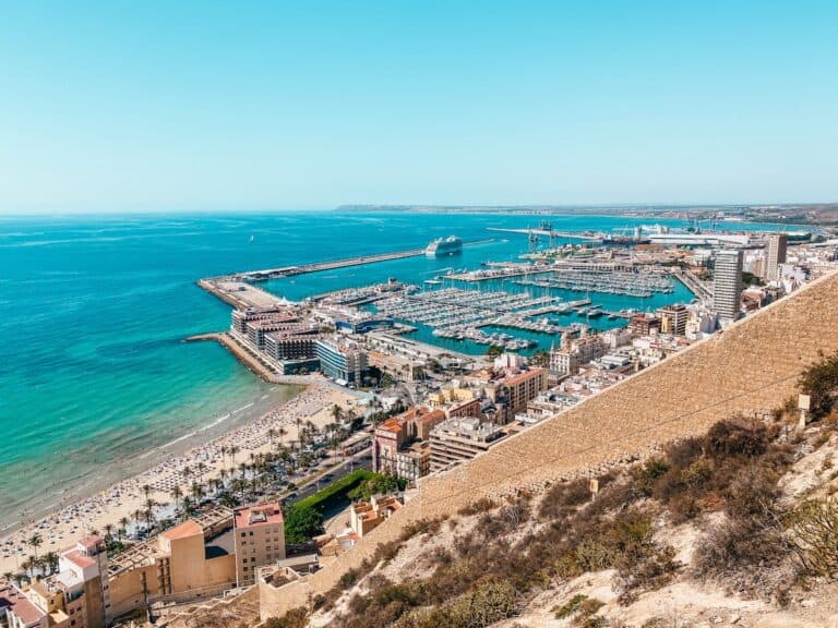 View of Santa Barbara castle in Alicante, you can see a bit of the castle walls, the city, the harbour and the ocean