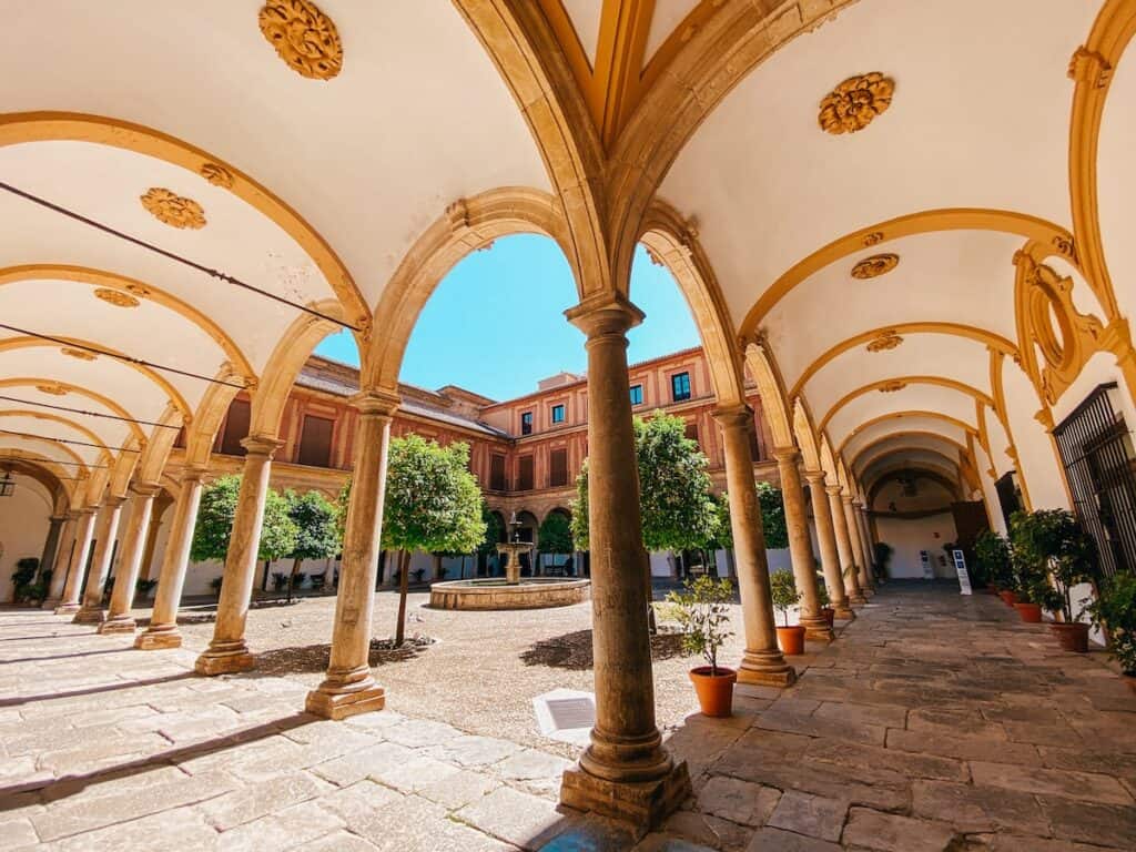 The cloister of Abadia del Sacromonte, it's a wide lense shot, you can see all the columns and the trees in the middle of the courtyard.
