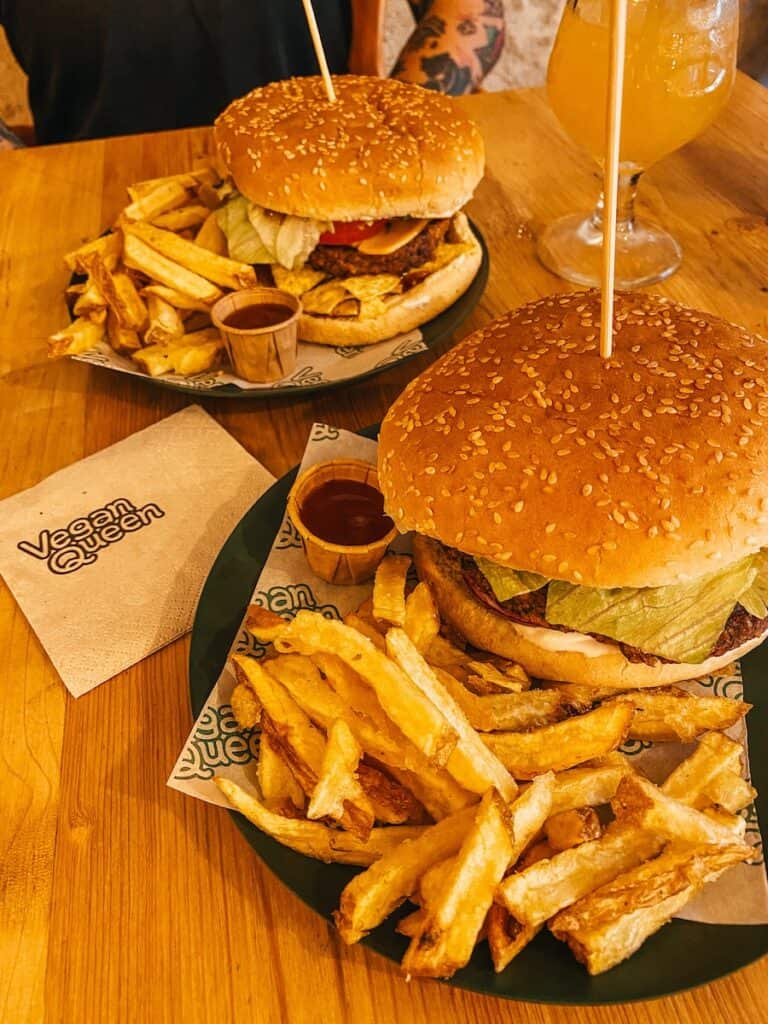 2 burgers with fries on two plates, next to it is a napkin with Vegan Queen written on it. You don't need to worry if your vegan Murcia has got you covered.