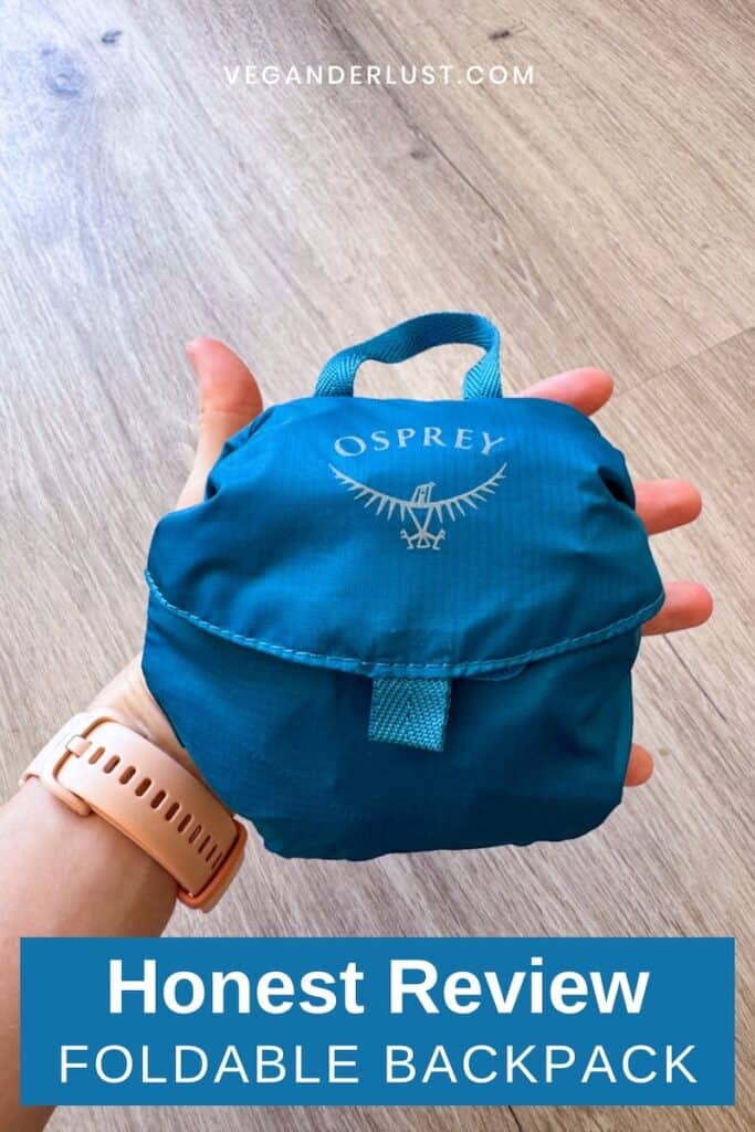 Hand holding a compact blue Osprey foldable backpack packed into its own small storage pouch. Text on the image reads “Honest Review” and “FOLDABLE BACKPACK.”